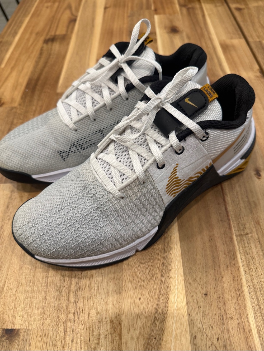 Nike White and Black Metcon Athletic Sneakers with Gold Swoosh